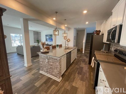 A kitchen with a stone counter and wooden floors.