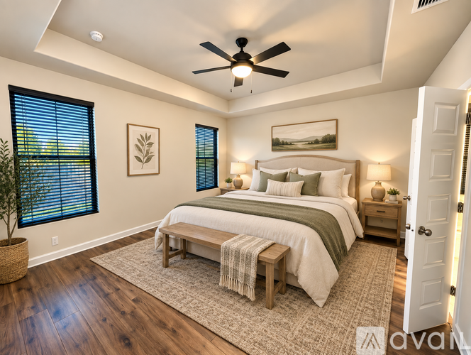 A bedroom with a large bed and a ceiling fan.