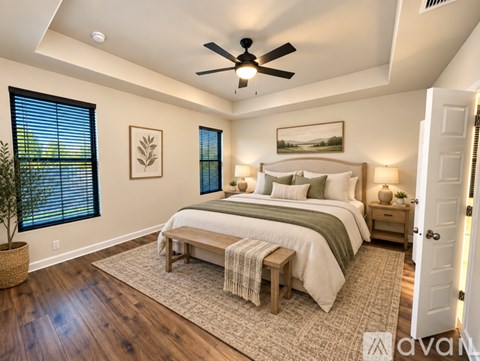 A bedroom with a large bed and a ceiling fan.