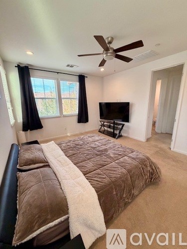 A bedroom with a large bed and a flat screen TV.