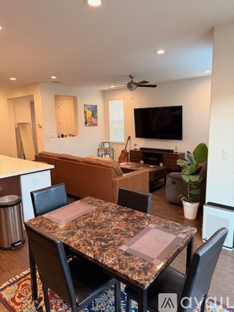 A modern kitchen with a marble table and chairs.