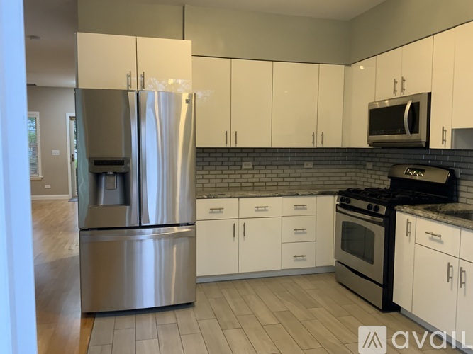 A kitchen with a stainless steel refrigerator, oven, and microwave.