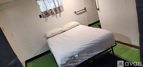 A small bedroom with a bed and a window.