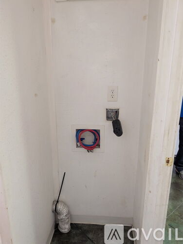 A white wall with a switch and a red and blue ring on it.