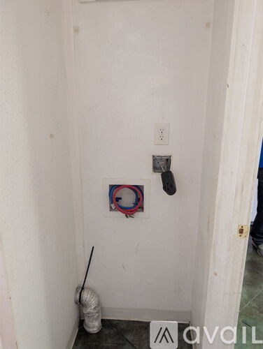 A white wall with a switch and a red and blue ring on it.