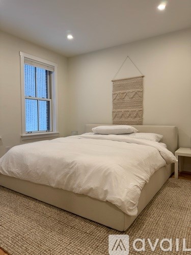 A bedroom with a large bed and a window.