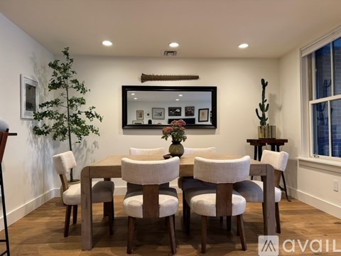 A dining room with a wooden table and chairs.