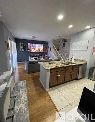 A kitchen with a granite countertop and wooden flooring.