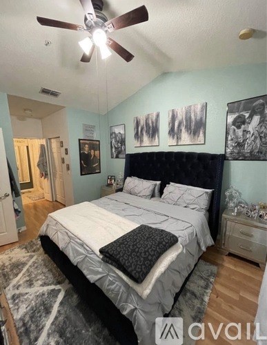 A bedroom with a large bed and a ceiling fan.