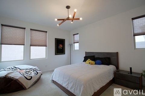 A bedroom with a white bed and a black headboard.