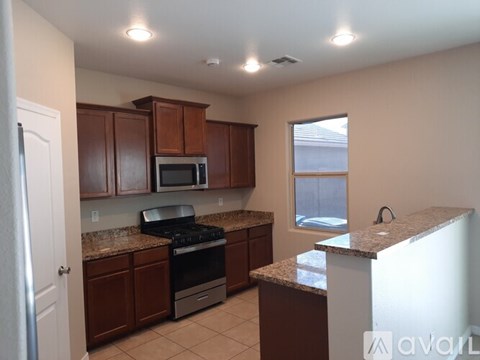 A kitchen with brown cabinets and a granite counter.