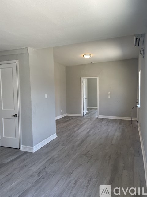 A room with a grey door and a grey floor.