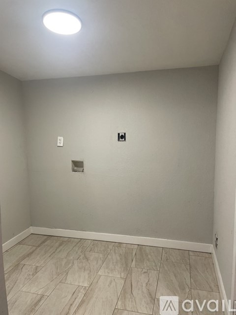 A room with a light on the ceiling and a tile floor.