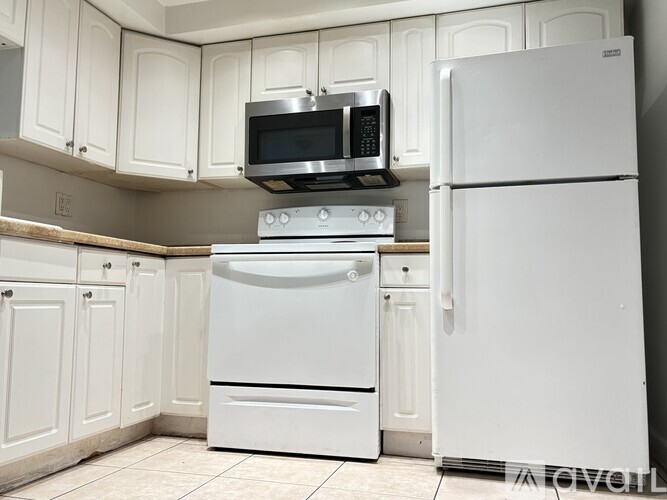 A white kitchen with a stove, oven, and microwave.
