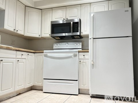 A white kitchen with a stove, oven, and microwave.