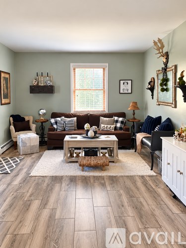 A living room with a brown couch, a coffee table, and a rug.