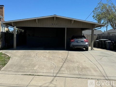 A car is parked in a garage with the numbers 5555 on the wall.