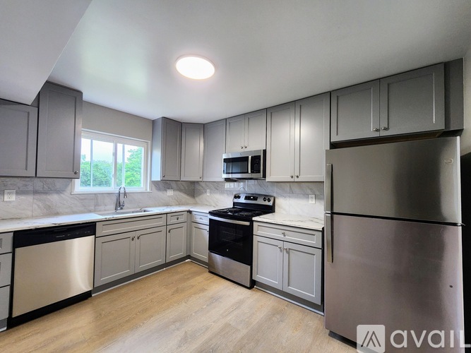 A kitchen with stainless steel appliances and wooden floors.