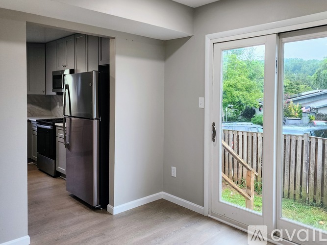 A kitchen with a refrigerator and a microwave.