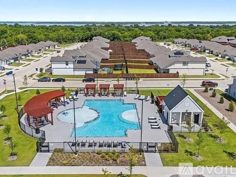 A community pool surrounded by houses and a pavilion.