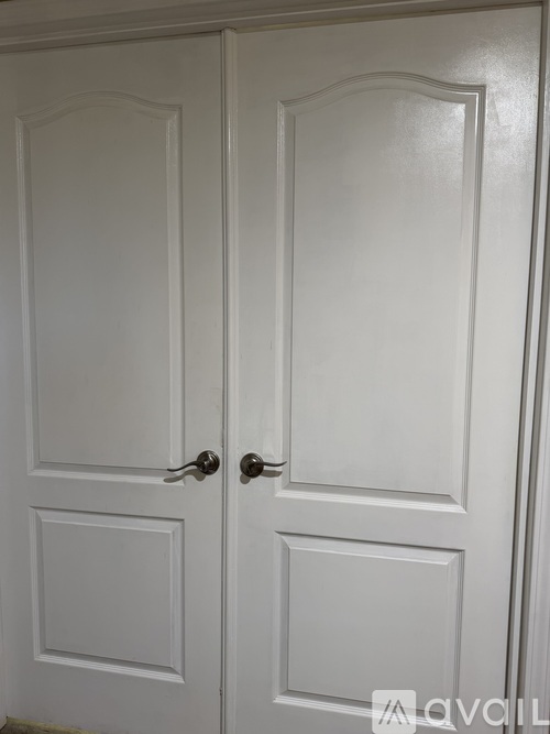 A white double door with a handle on each side.