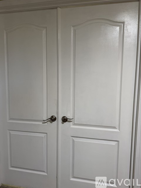 A white double door with a handle on each side.