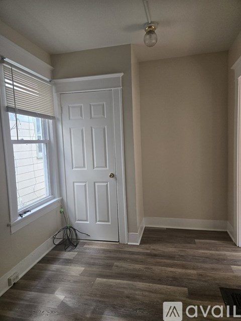 A room with a white door and a window with blinds.