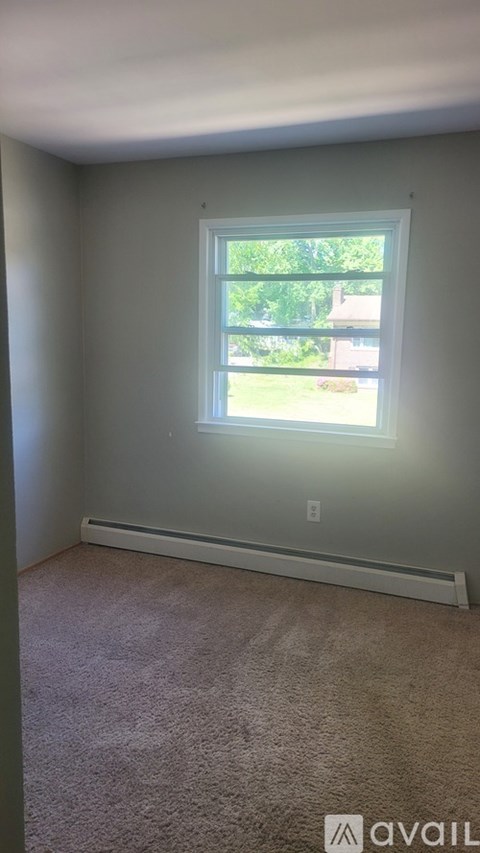 A room with a window and carpeted floor.