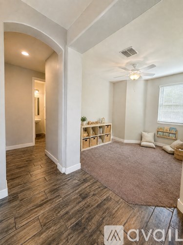 A living room with a brown rug and wooden flooring.