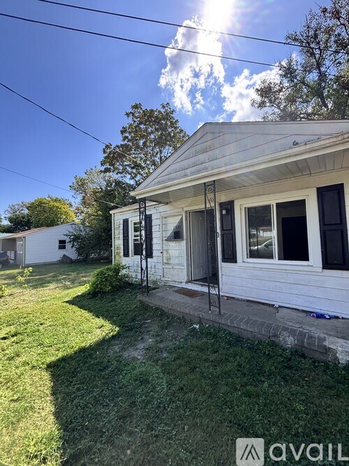 A house with a white exterior and a porch is shown in the image.