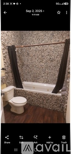 A bathroom with a toilet, a bathtub, and a shower curtain.