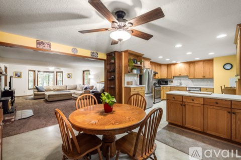 A dining room with a wooden table and chairs.
