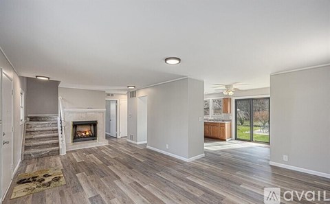 A spacious living room with a fireplace and hardwood floors.