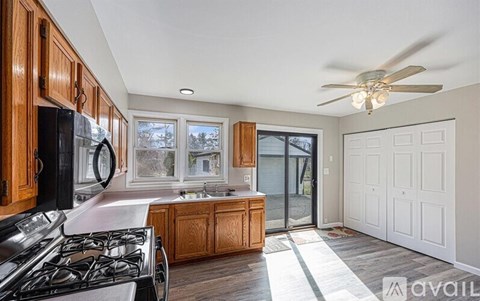 A kitchen with wooden cabinets and a black stove top oven.