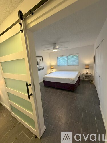 A bedroom with a bed, a window, and a door.