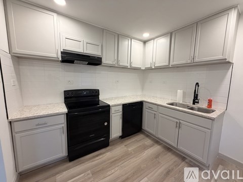 A kitchen with white cabinets and a black stove top oven.