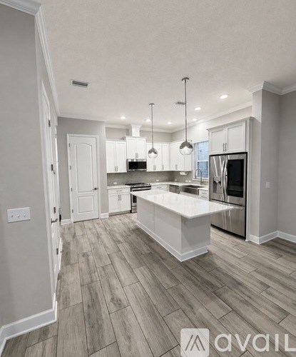 A modern kitchen with a large island and stainless steel appliances.