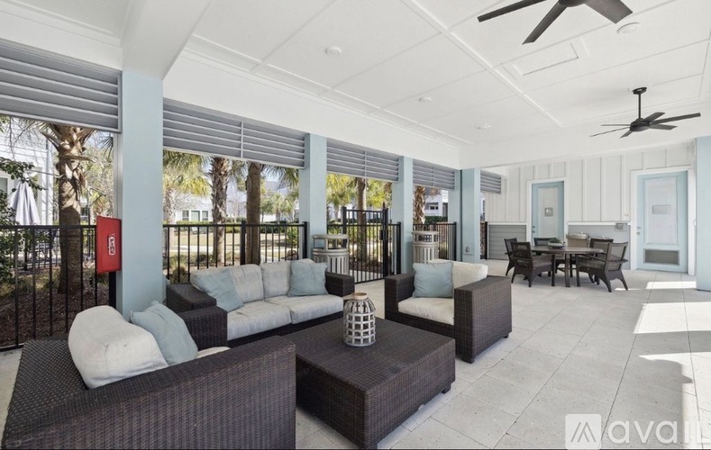 A spacious outdoor living area with a sofa set, coffee table, and a dining table.