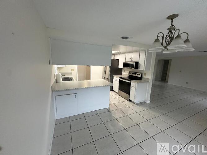 A kitchen with white cabinets and a tiled floor.