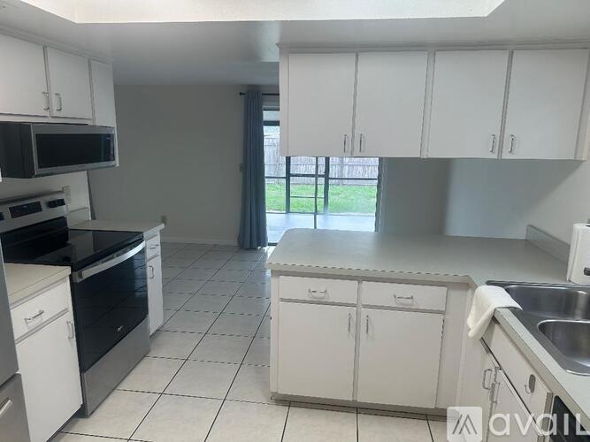 A kitchen with white cabinets and black appliances.