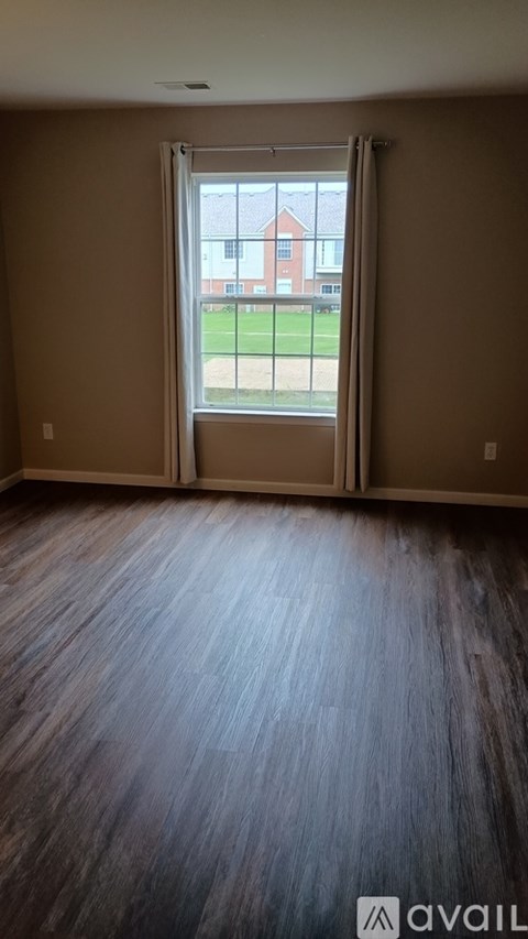A room with a sliding glass door leading to a grassy area.