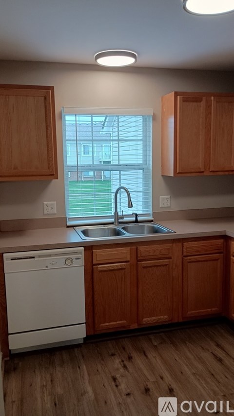 A kitchen with wooden cabinets and a white dishwasher.