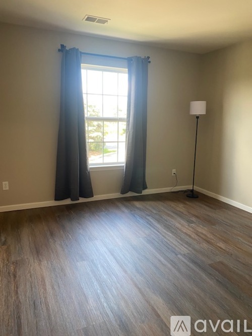 A room with a window and a floor lamp.