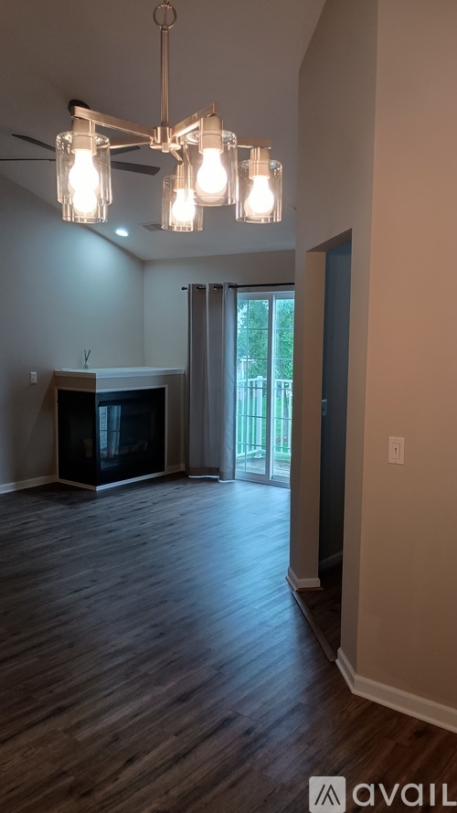 A hallway with a white door and a window in the background.