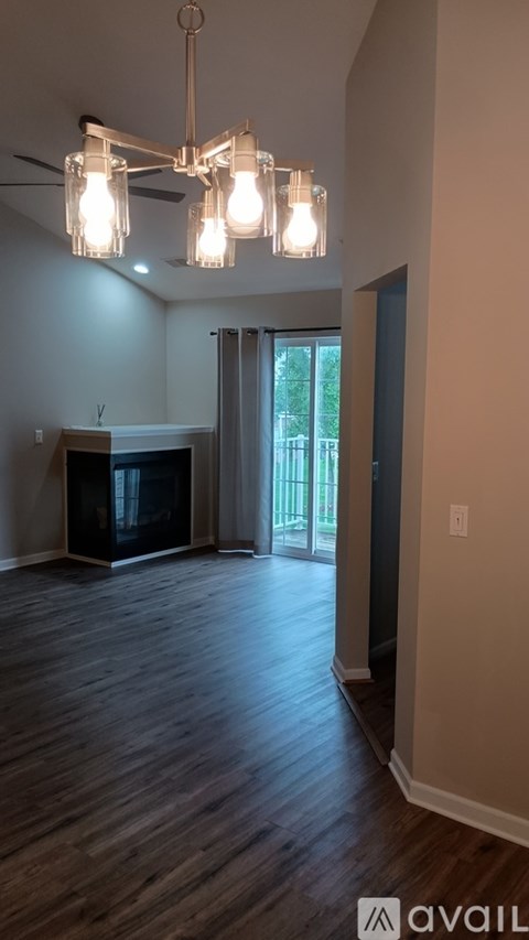 A hallway with a white door and a window in the background.