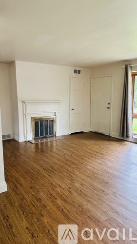 A room with wooden floors and a fireplace.