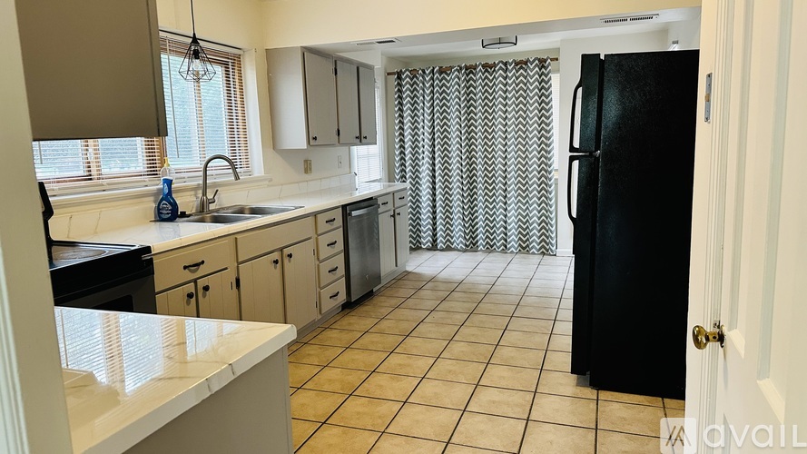 A kitchen with black appliances and white cabinets.