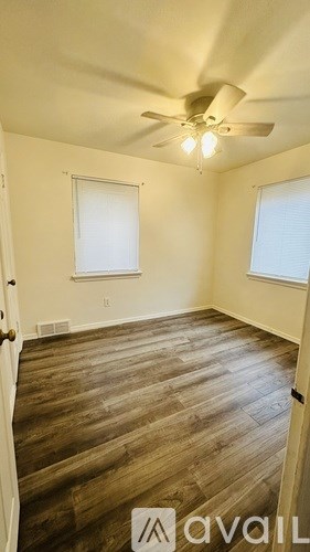 A room with wooden flooring and a ceiling fan.