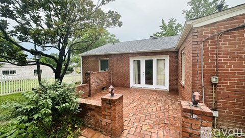 A small brick house with a white door and windows.