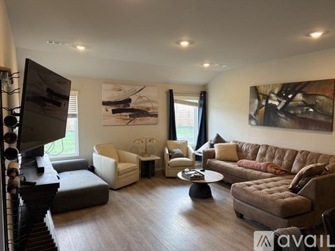 A living room with a brown couch and a television.